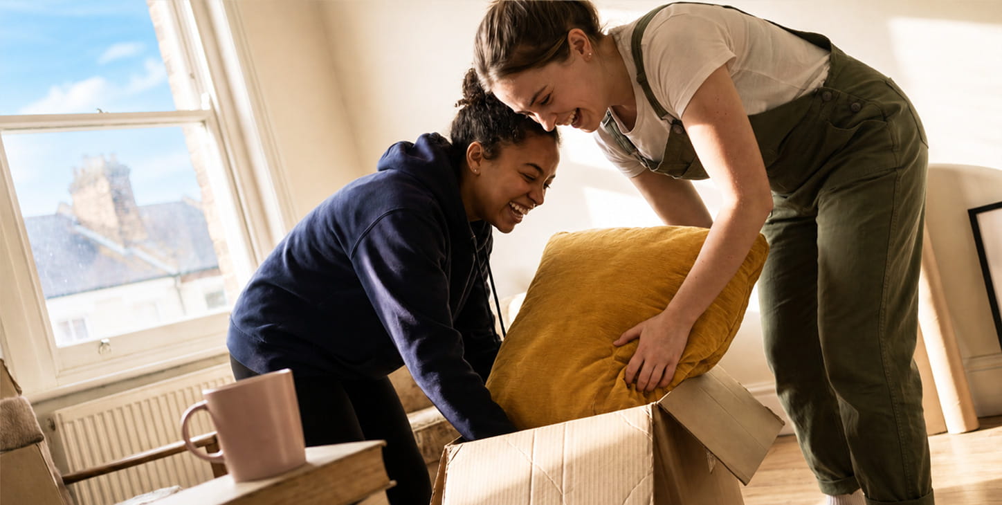 Two people moving a sofa together